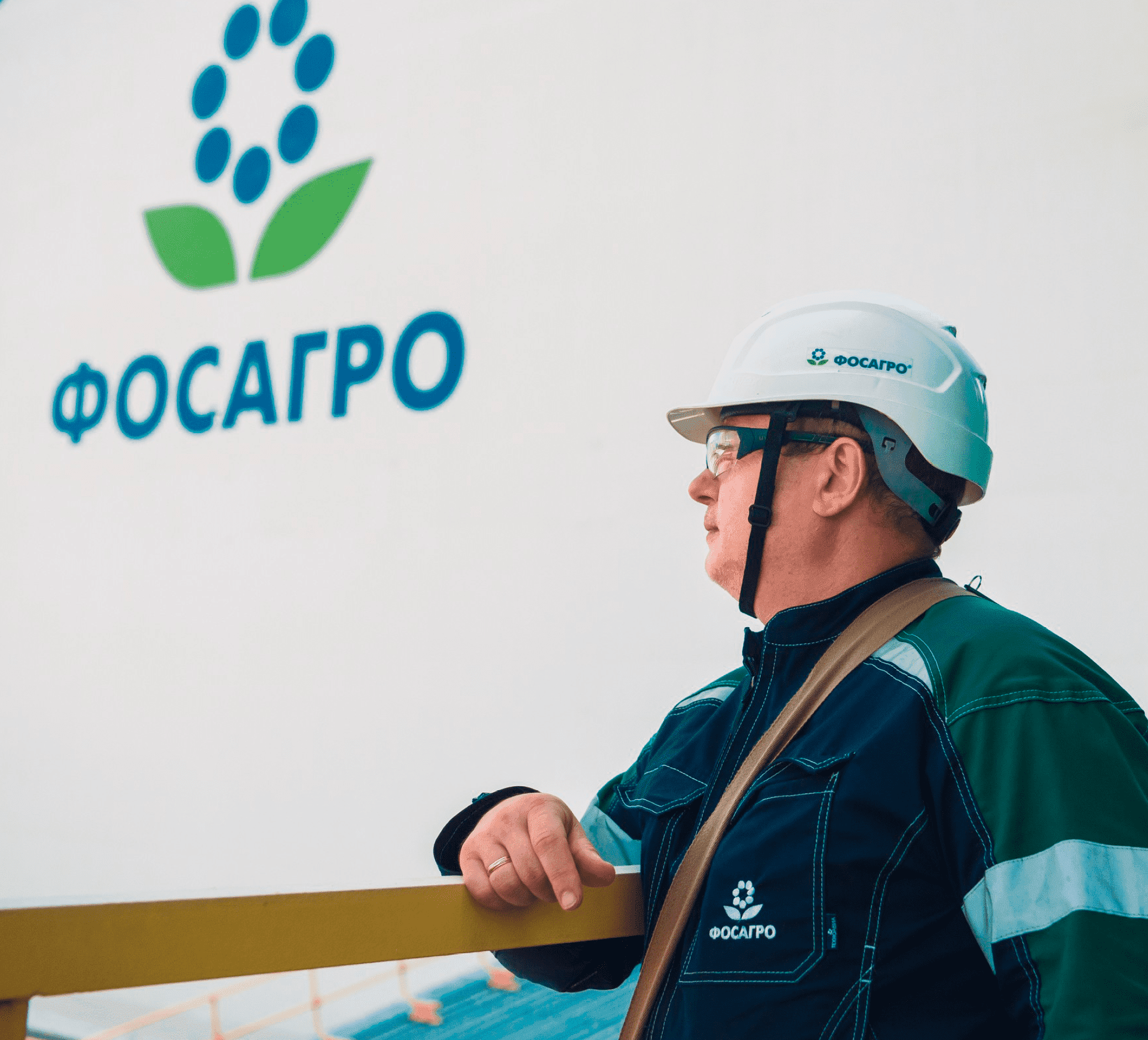 Рабочий на фоне логотипа Фосагро